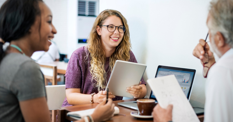 Teaching faculty smile around a table.